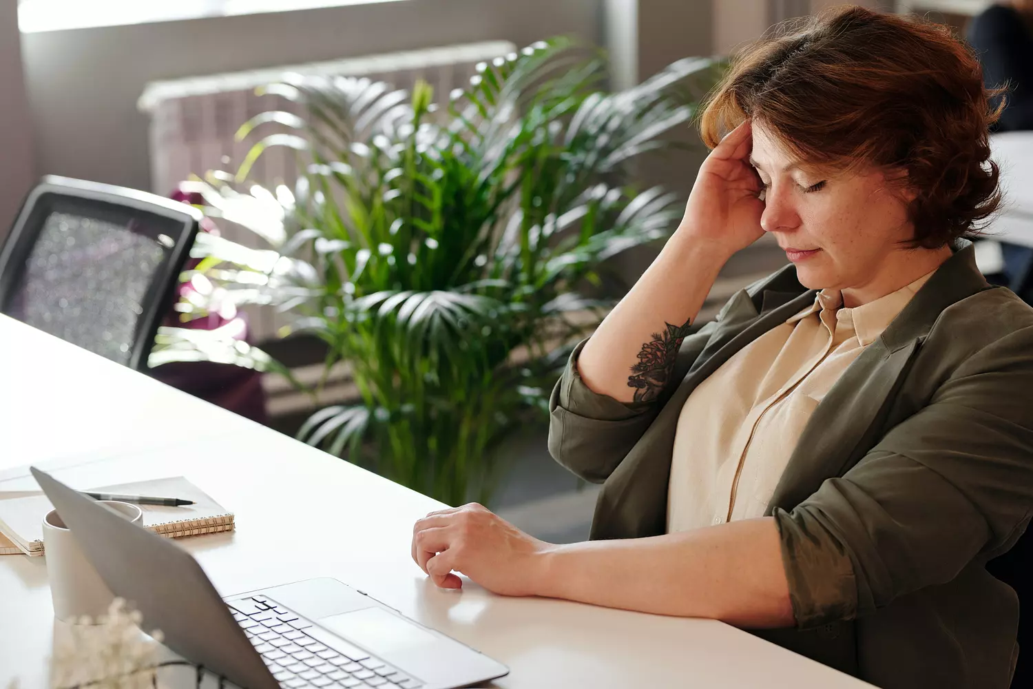 kwijtschelding - vrouw hoofdpijn achter laptop
